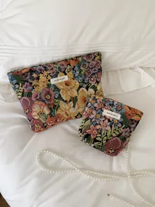 Detailed shot of vintage floral tapestry cosmetic bags with pearl chain, elegant storage pouch.