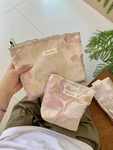 Detailed view of the gold-thread floral jacquard cosmetic pouch, elegant travel bag.