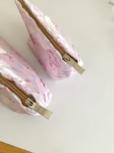 Close-up detail of pink cosmetic bag with zipper, portable makeup pouch and pencil case.