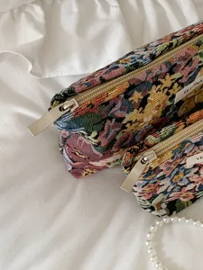Vintage floral jacquard cosmetic bag with smooth metal zipper for daily travel storage.