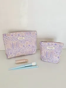 Detail shot of woven floral cosmetic makeup bag set, showing soft texture and fabric label.