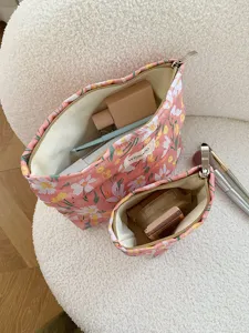 Detailed shot of pink floral embroidered cosmetic makeup bag set with smooth zipper and lining.