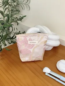 Detail view of the pink floral jacquard cosmetic pouch, showing delicate fabric texture and zipper.