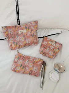 Detailed view of floral embroidered cosmetic bag set, portable travel makeup storage pouch.