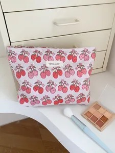 Detailed shot of a stylish canvas makeup pouch with cute strawberry print and zipper.