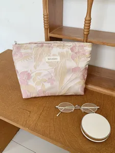 Detail shot of the floral jacquard cosmetic bag featuring embossed texture and smooth zipper.