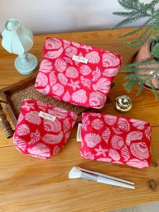 Detail view of pink seashell print cosmetic bag, large capacity travel makeup pouch.