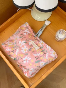 Pink floral embroidered cosmetic pouch with zipper, stylish portable travel makeup storage bag.