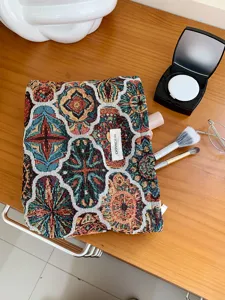 Close-up view of the vintage woven cosmetic pouch showing detailed geometric tapestry pattern and label.