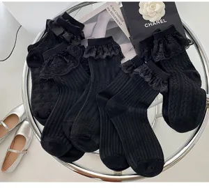 Nahaufnahme schwarzer Rüschen-Spitzen-Mittelsocken, süßer Lolita-Stil mit feinen Schleifendetails.
