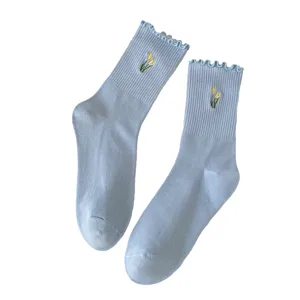 Light blue women's mid-tube socks with sweet lettuce ruffles and cute embroidered flower details.