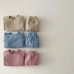 Close-up view of kids ribbed long-sleeve top and trousers set showing soft elastic fabric texture.