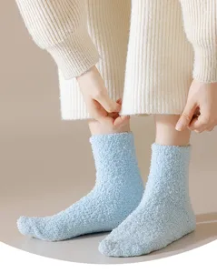 Close-up of light blue fluffy fuzzy socks, soft plush winter thermal floor socks.
