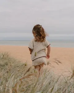 Ensemble pull tricot bambou détail, haut manches courtes bord contrasté plage scène.