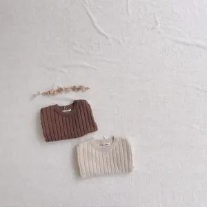 Gros plan détaillé de l'ensemble pull en tricot côtelé pour bébé en marron et beige, style épuré.