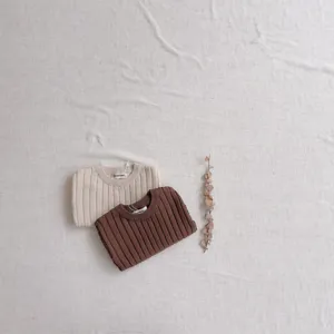 Détail de pull en tricot côtelé pour bébé, matière douce, style haut à manches courtes