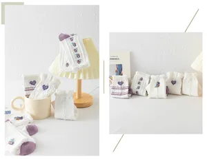 Primer plano de calcetines blancos japoneses con bordado floral morado y lindos puños de encaje.