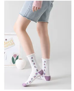 Calcetines blancos media pantorrilla con bordado floral morado, ribete con volantes y color.