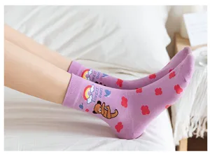 Detailopname van schattige paarse katoenen sokken met lieve beren- en regenboogmotieven.