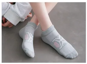 Gros plan détaillé sur des chaussettes de sport grises respirantes avec motif rose.