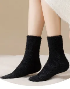 Gros plan detail de chaussettes douillettes noires pelucheuses, texture chaude hiver.