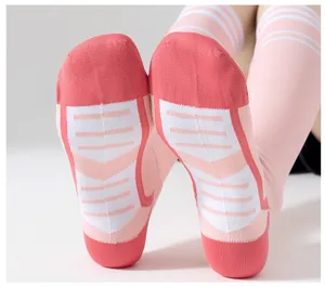 Vue détaillée de chaussettes de yoga de compression roses avec semelles antidérapantes.
