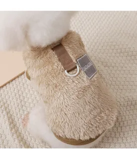 Close up of a cute dog wearing a fluffy camel fleece vest with leash ring and brand tag.