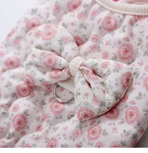 Detailed shot of quilted floral pet cotton vest with cute bow and metal d-ring for small dogs.