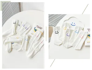 Chaussettes en coton blanc pour femmes, style japonais avec motifs de visages souriants.