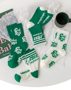 Gros plan de chaussettes en coton vert et blanc tendance avec des imprimés élégants.