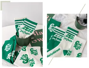 Chaussettes mi-hautes rayées vertes en coton vue détail, lettres tricotées style tendance.