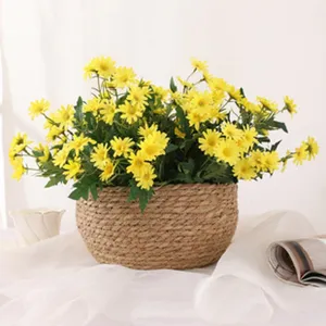 Kunstliche gelbe Gänseblümchen im geflochtenen Korb ländliche Heimdeko Blumenarrangement