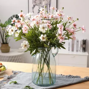 Wunderschöner künstlicher Kosmeen Blumenstrauß in transparenter Glasvase für die Heimdekoration.