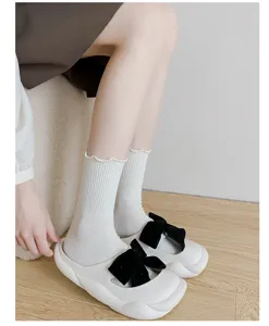 Close-up detail shot of white ribbed mid-tube socks featuring cute lettuce edge ruffles.