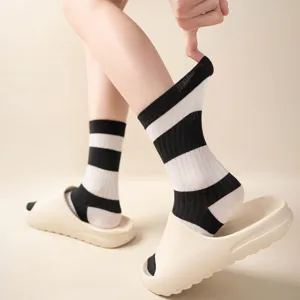 Damen Baumwoll-Mittelsocken mit schwarz-weißen Streifen, klassische modische Freizeitkleidung.