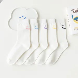 Chaussettes mi-hautes blanches mignonnes pour femmes avec broderie souriante multicolore.