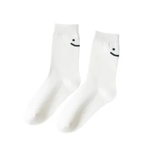 Chaussettes mi-hautes blanches en coton pour femmes avec une broderie smiley noire.
