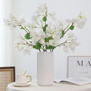 Künstliche Bougainvillea Blumen in weißer Keramikvase für die Wohnzimmerdekoration.