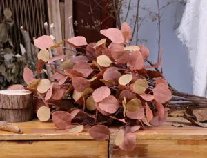 Artificial eucalyptus leaves stem branches fake greenery floral arrangement detail view.