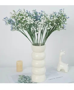 Bouquet de fleurs artificielles gypsophile bleu blanc dans un vase en céramique blanche pour la déco.