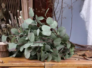 Detail view of artificial eucalyptus leaves branch, realistic green foliage for floral decor.