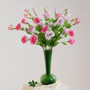 Artificial Eustoma flower bouquet in green glass vase for home decor and wedding floral design.