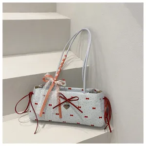 Detail shot of the cute shoulder bag with red bows, lace ribbons, and stylish design features.