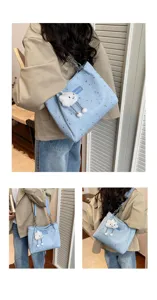 Detailed view of light blue star print tote bag with cute cloud plush charm and chain strap.