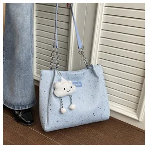 Detail shot of the light blue star-printed tote bag with cute cloud pendant and chain strap.