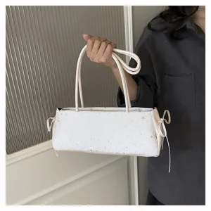 Close-up detail of the white star-patterned underarm bag featuring side bow ties and dual straps.