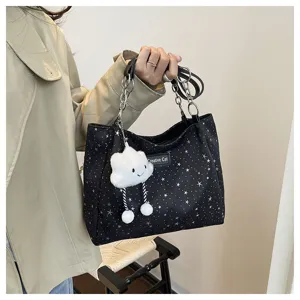 Detailed view of the stylish black star pattern tote bag with metal chains and plush cloud charm.