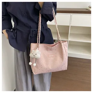 Vista dettagliata di una borsa tote rosa in tela con stampa di stelle e manici intrecciati.