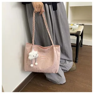 Dettaglio borsa shopper con motivo a stelle rosa, ciondolo a nuvola e tracolla intrecciata.