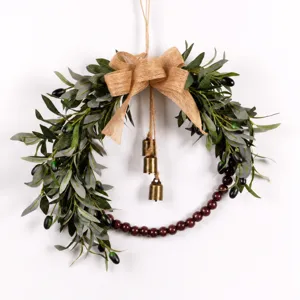 Artificial olive leaf wreath detail showing vintage wooden beads, burlap bow and cute hanging bells.